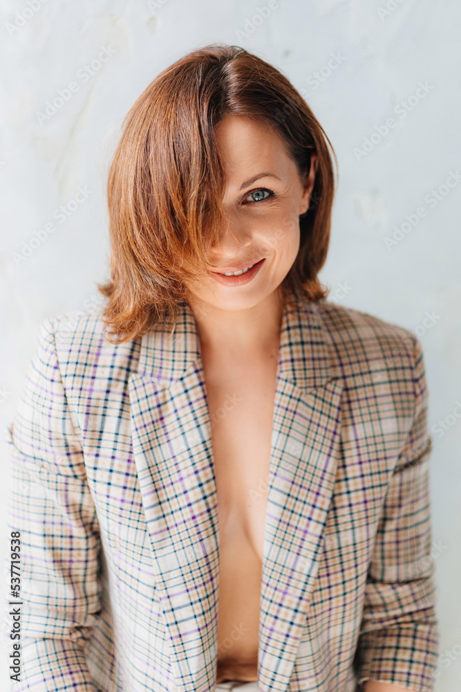 attractive and sexy brunette woman in a plaid jacket on a naked body. attractive and sexy brunette woman in a plaid jacket on a naked body.