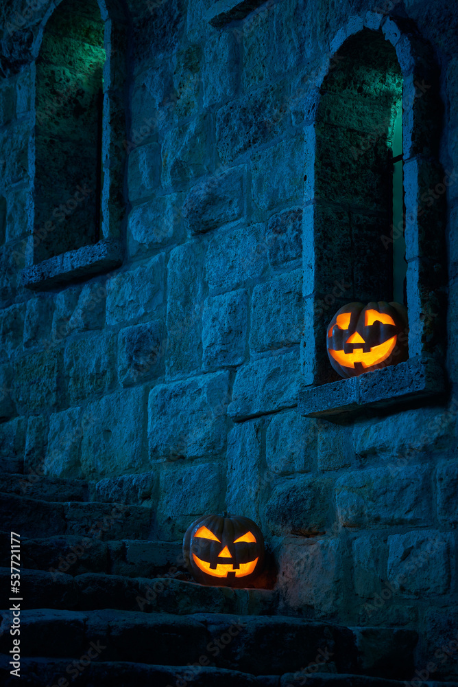 Halloween pumpkins jack p lantern in the yard of an old castle at night in the bright moonlight - obrazy, fototapety, plakaty 