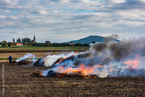 Farmers burn the dry grass and straw stubble on field in autum, another cause of global warming. Air pollution.