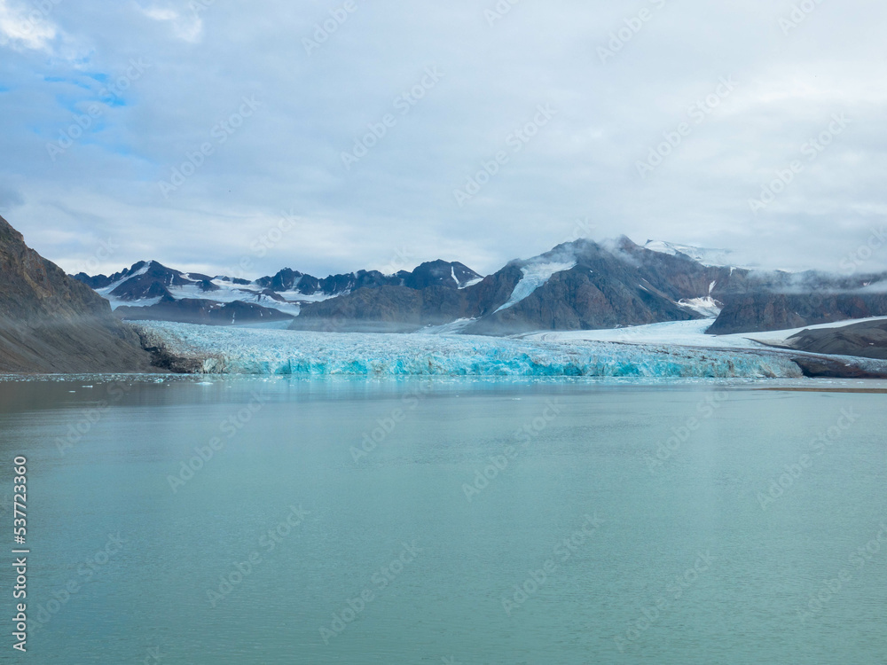 Panorama view of the 14th of July Glacier or the Fjortende Julibreen. Is a beautiful glacier found in northwestern Spitsbergen. Floating Pack Ice in the arctic ocean. Dramatic sky with place for text.