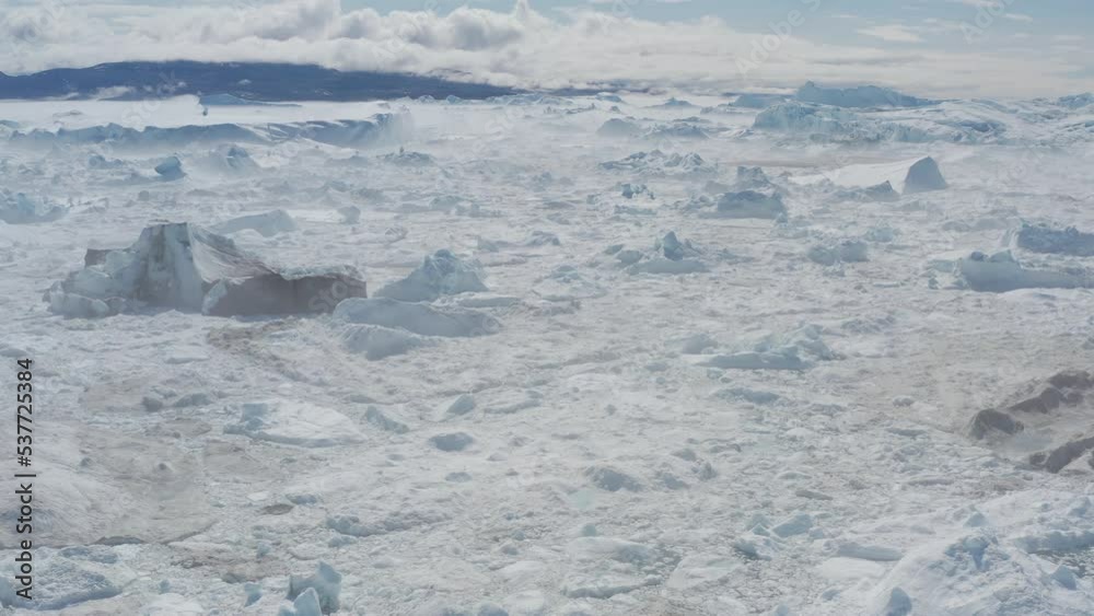 Icebergs drone aerial video top view - Climate Change and Global Warming - Icebergs from melting glacier in icefjord in Ilulissat, Greenland. Arctic nature ice landscape in Unesco World Heritage Site. Icebergs drone aerial video top view - Climate Change and Global Warming - Icebergs from melting glacier in icefjord in Ilulissat, Greenland. Arctic nature ice landscape in Unesco World Heritage Site.