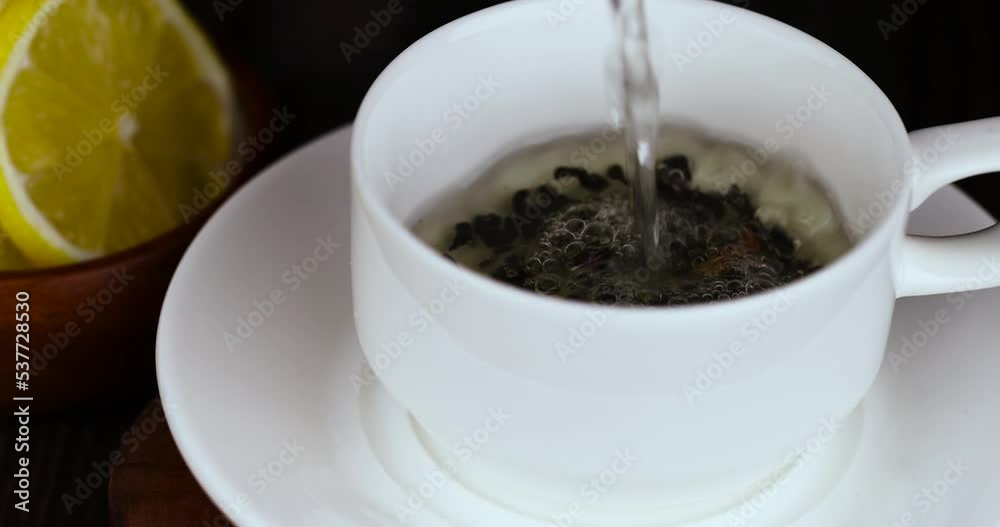 Prepare green tea with lemon in a white cup, a white cup with boiled tea and lemon
