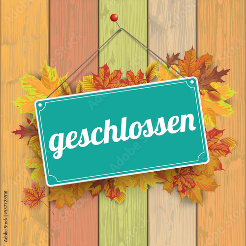 Schild geschlossen auf einer Holzwand mit Herbstlaub