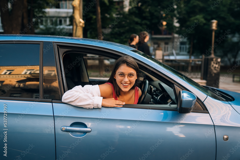 Happy woman in a car, looking out of the window. Happy woman in a car, looking out of the window.