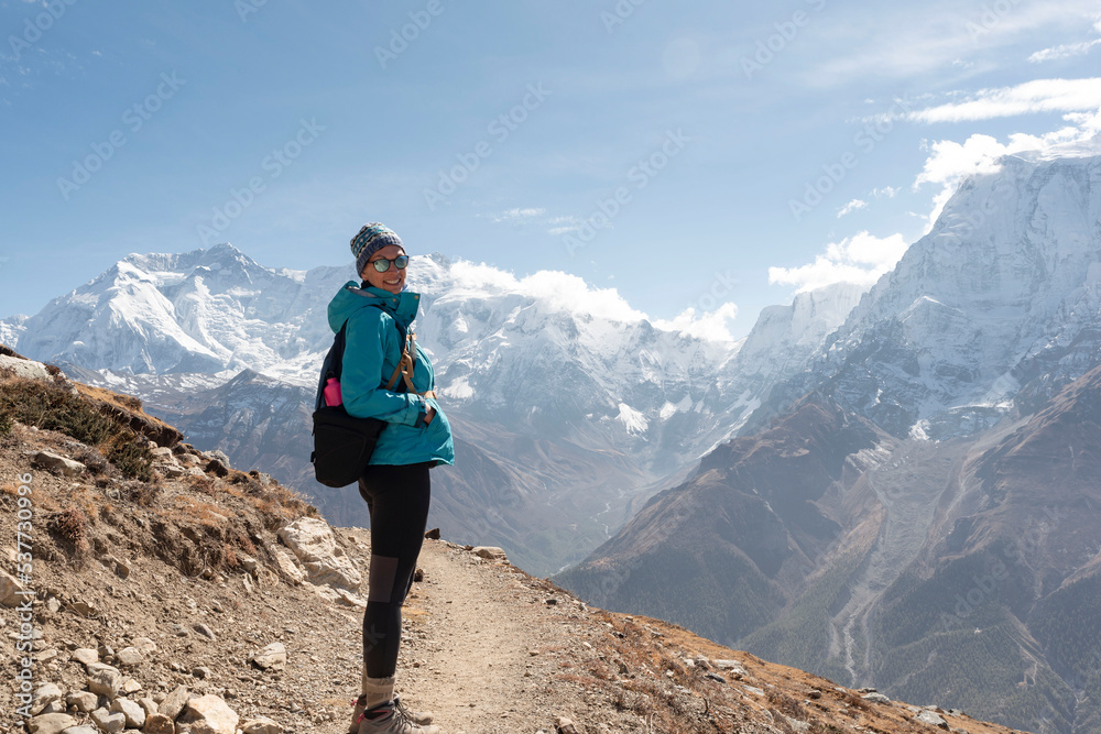 A woman hiking Annapurna Circuit Trek, Himalayas, Nepal. High mountains all around