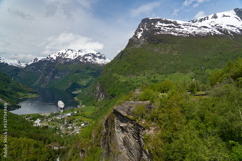 Obraz premium Beautiful view of the Geiranger Fjord and the town of Geiranger from the Adlerkehre with a cruise ship at anchor