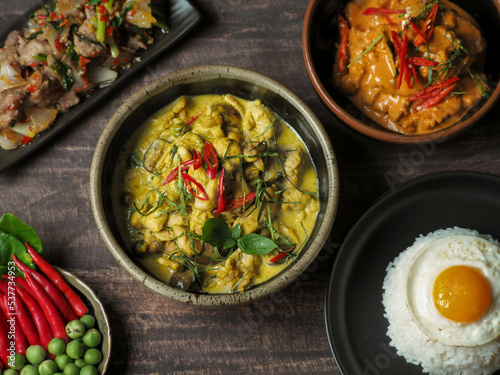 A full set of Thai food on a wood table