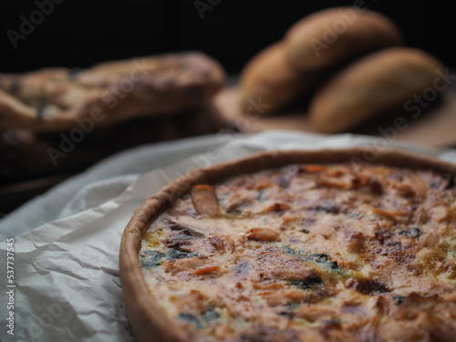 Home made salmon Quiche on a wood table with beautiful light for background