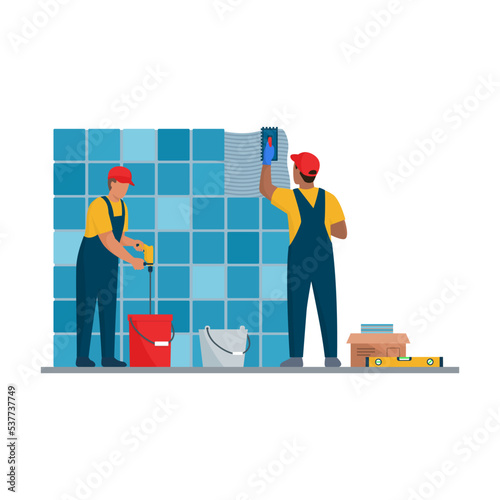 Professional tilers installing tiles on a wall