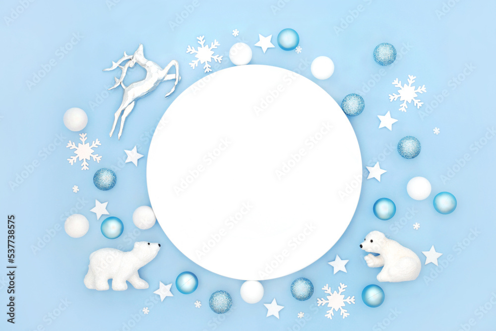 Christmas fun north pole theme dinner plate table place setting with polar bear, reindeer, frosted tree decorations. Abstract for Xmas New Year festive holiday season. On pastel blue. Christmas fun north pole theme dinner plate table place setting with polar bear, reindeer, frosted tree decorations. Abstract for Xmas New Year festive holiday season. On pastel blue.
