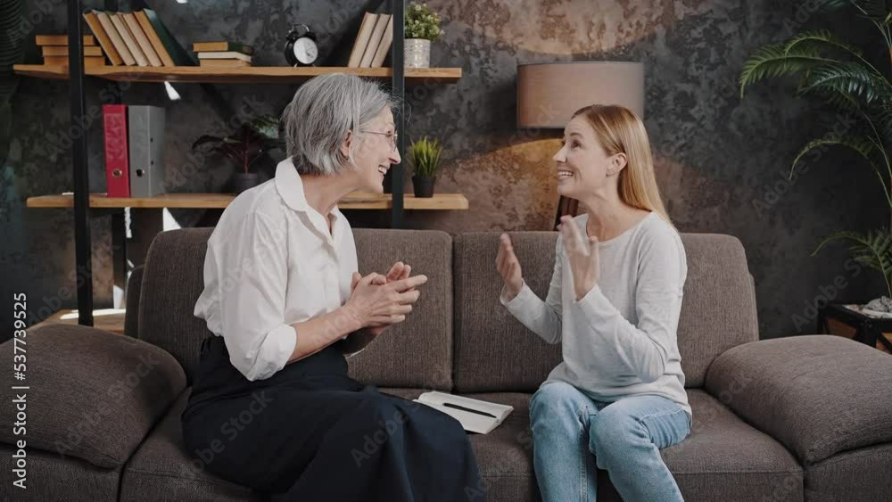 Blonde woman shares happiness with grey-haired psychologist Blonde woman shares happiness with grey-haired psychologist
