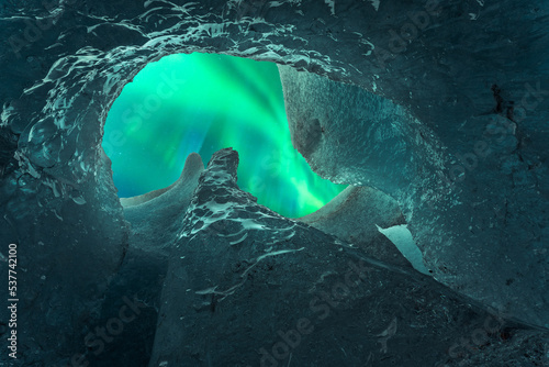 Amazing view of aurora borealis throughout hole in ice cave photo