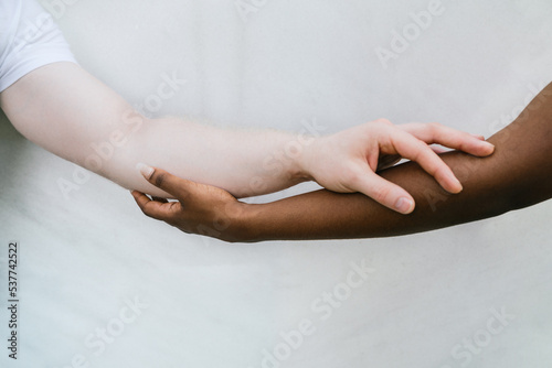 Crop multiracial couple holding hands together photo