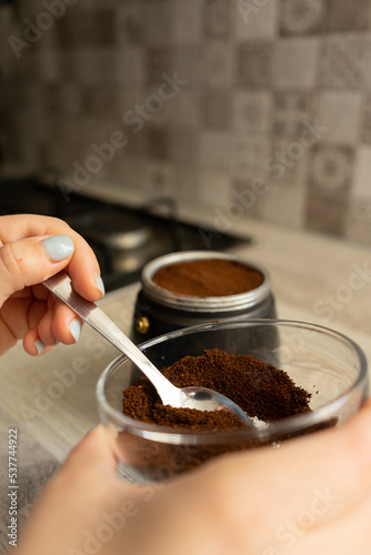 girl with a coffee pot filled with coffee with brown must to prepare traditional Italian coffee