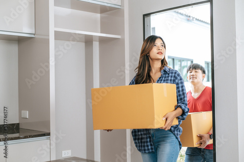 Young couple moving package into new house.