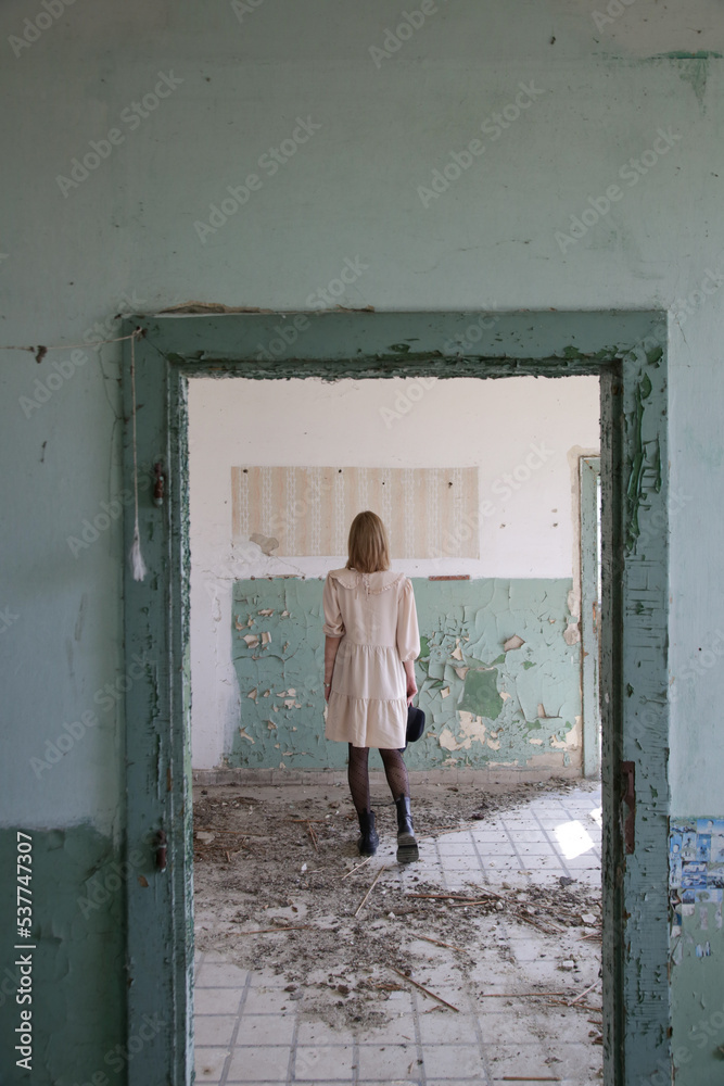 Serie of photos of female model in beige dress in the abandoned ruined building