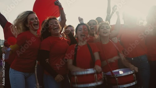 Crowd football fans cheering while watching soccer game at stadium - Sport entertainment concept