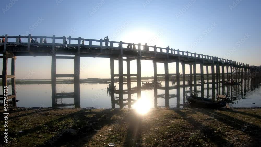 The setting Sun reflecting in the Water at U Bein Wooden Foot Bridge build around 1850 at Amarapura The setting Sun reflecting in the Water at U Bein Wooden Foot Bridge build around 1850 at Amarapura