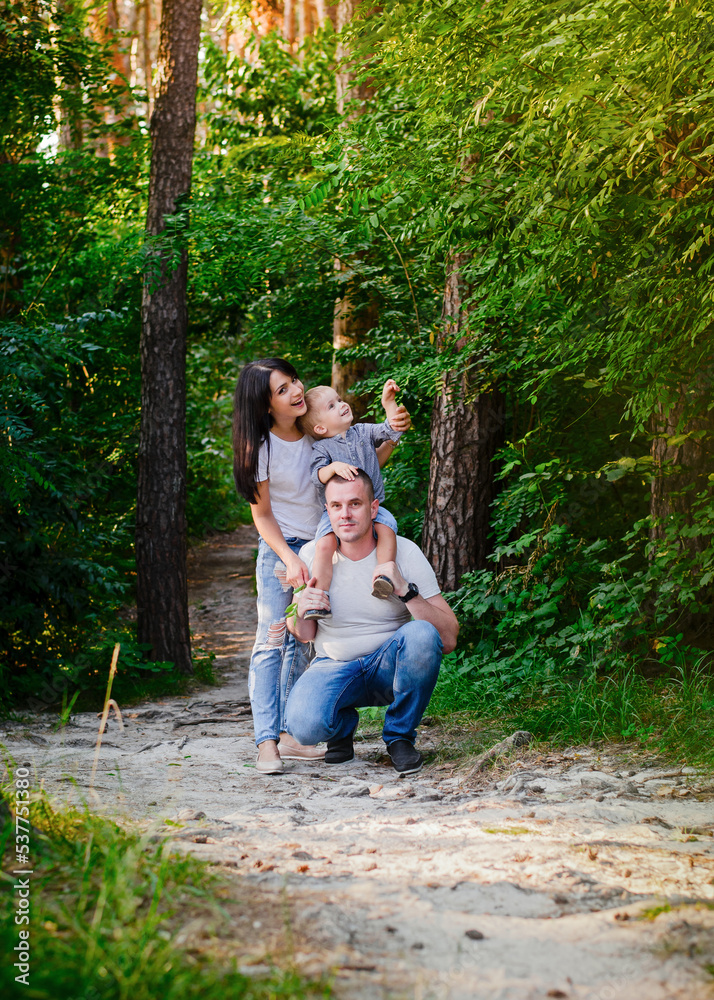 Beautiful happy Ukrainian family in the forest in summer. Mom, dad and son 2 years old in the forest. Beautiful happy Ukrainian family in the forest in summer. Mom, dad and son 2 years old in the forest.