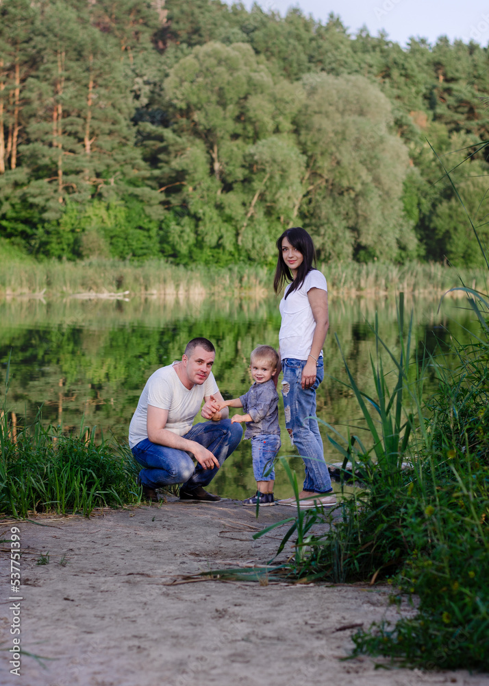 Beautiful happy Ukrainian family in the forest in summer. Mom, dad and son 2 years old in the forest. Beautiful happy Ukrainian family in the forest in summer. Mom, dad and son 2 years old in the forest.