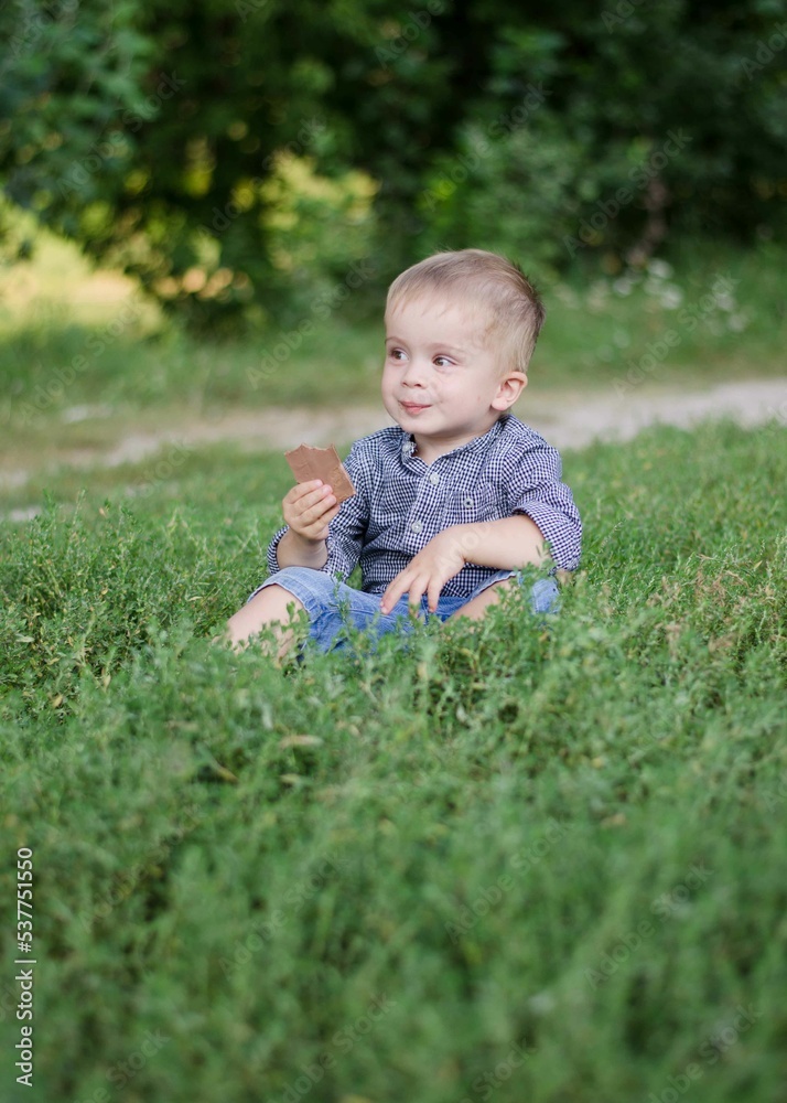 Boy 2 years old eats chocolate in nature. A child covered in chocolate. Boy 2 years old eats chocolate in nature. A child covered in chocolate.