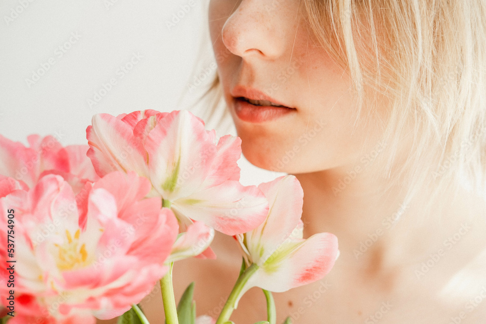 A woman gently kisses tulips. Lips of a woman with tulips.