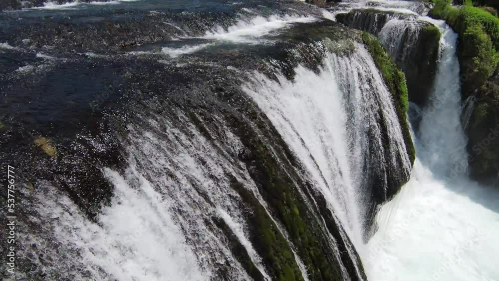 FPV Aerial shot skilled flying at natural landscape river Una with waterfall Strbacki Buk in the dense green forest under trees. FPV Aerial shot skilled flying at natural landscape river Una with waterfall Strbacki Buk in the dense green forest under trees.