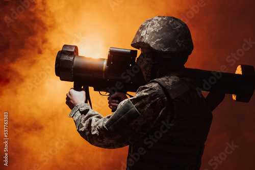 Military missile, combat, combat, war, big gun shooting. Action. Silhouette of a military soldier firing a grenade launcher. studio shot with colour orange smoke 