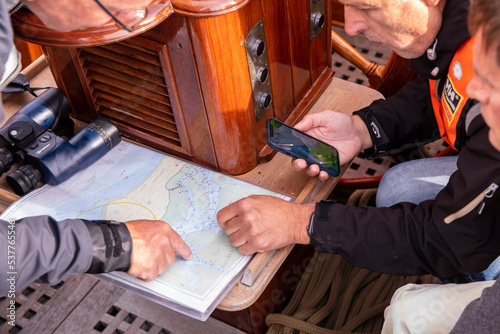 tactics discussion on a classic dutch flatboat during a sailing race photo