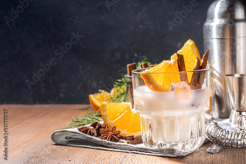Autumn alcohol drink, boozy refreshing milk and honey cocktail with benedictine orange and cinnamon spice, wooden kitchen table background copy space photo