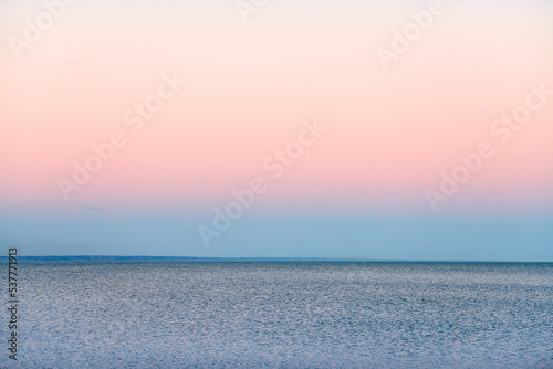 Atmospheric romantic pink red sea sunset sky above blue quiet water, minimalistic peaceful seascape, beautiful background copy space. Pinkish sky above Azov sea horizon, Rostov on Don region in Russia photo