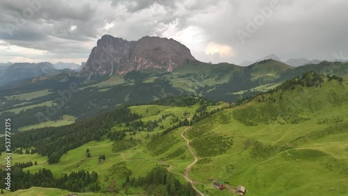 Aerial video of the sunrise in the Dolomites mountains. It was shot on the beautiful meadows of Seiser Alm plateau with fog and mist in the morning. photo