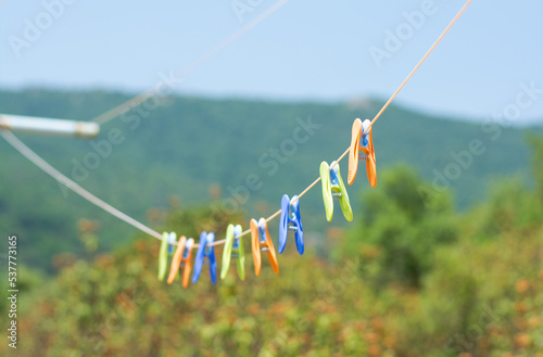 Obraz na płótnie Colored clothespins hang on a rope in a row at a mountain landscape w salonie