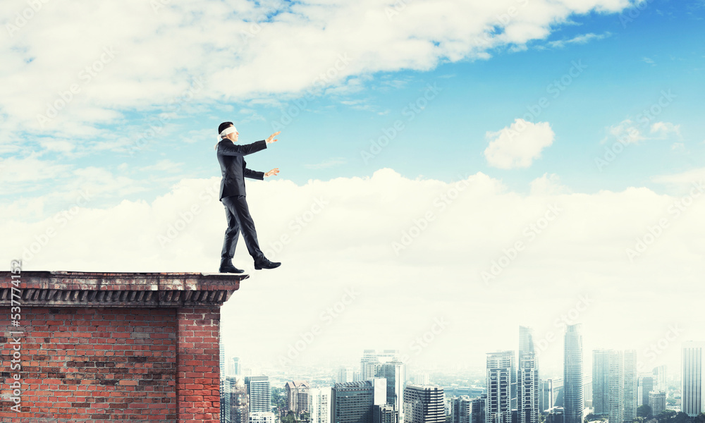 Danger and risk concept with businessman making step from edge Danger and risk concept with businessman making step from edge