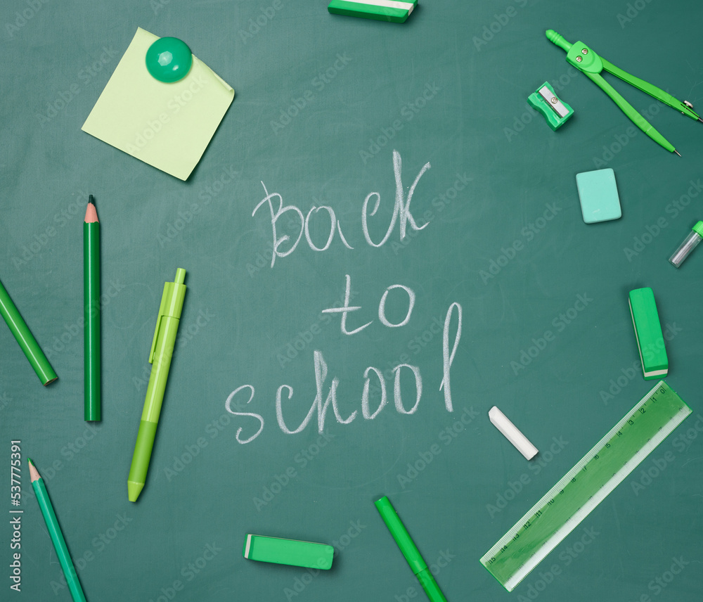School supplies on empty green chalk board, top view. School supplies on empty green chalk board, top view.