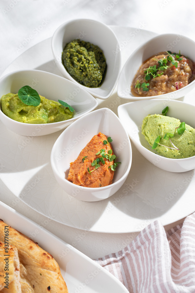 Israeli snack set - matbucha with eggplant, guacamole, edamame bean hummus, tuna rillette, olive and anchovy tapenade