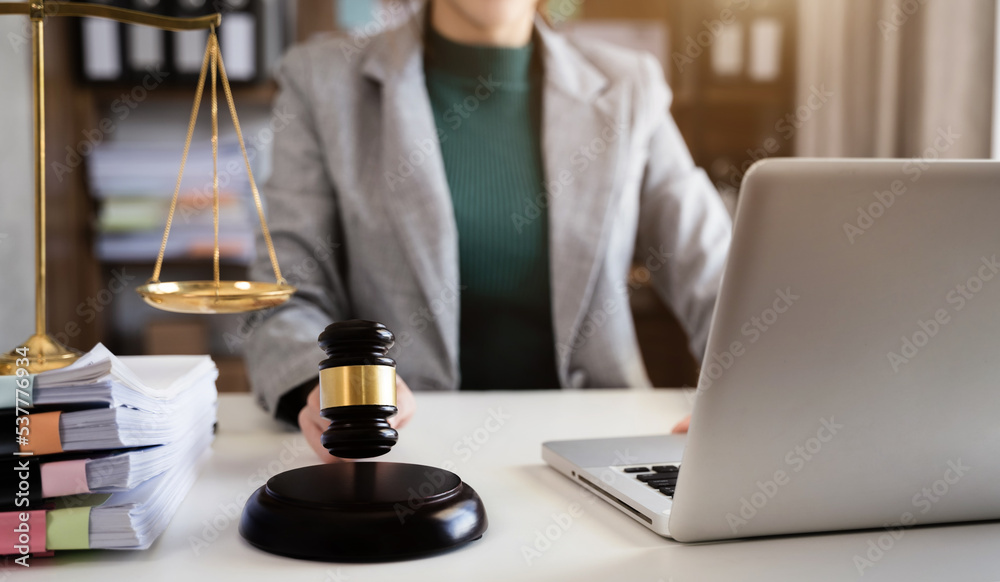 Woman judge hand holding gavel to bang on sounding block in the court room. Woman judge hand holding gavel to bang on sounding block in the court room.