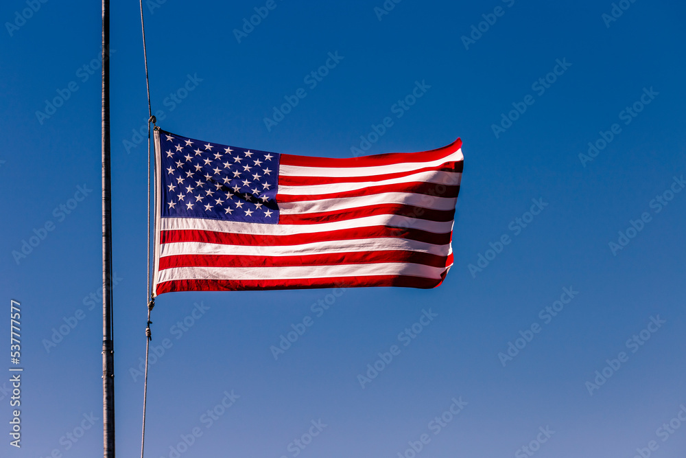American flag blowing on blue sky at half mast in New York, september 11, USA