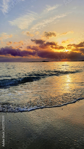 Sunset sky over sea in the evening with colorful clouds and warm sunlight.