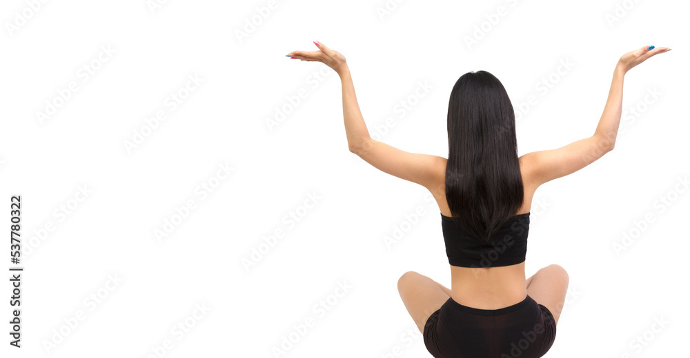 A back view of a sport woman doing yoga  wearing a black sports bra isolated on a white background free from copy space. Young female long hair raising hands doing yoga.