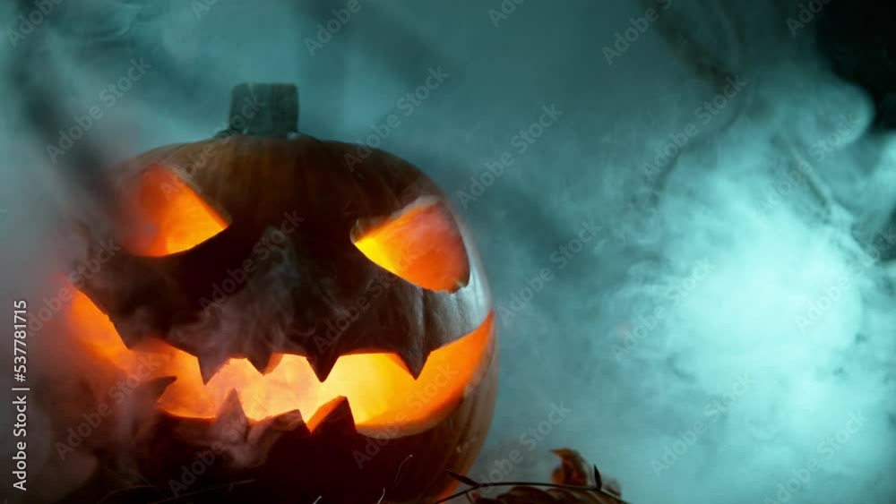Scary Pumpkin Jack O Lantern with Flaring Candles. Halloween Background. Super Slow Motion Filmed on High Speed Cinema Camera at 1000 fps.