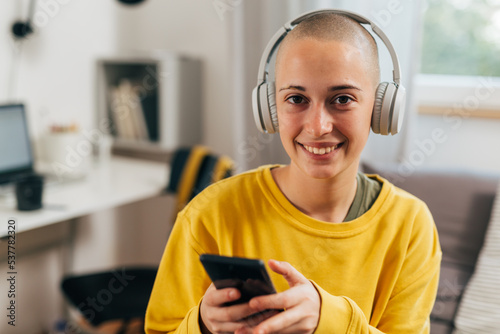 generation z female with headphones using mobile phone