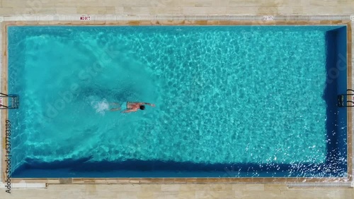 A man swims in a blue pool top view