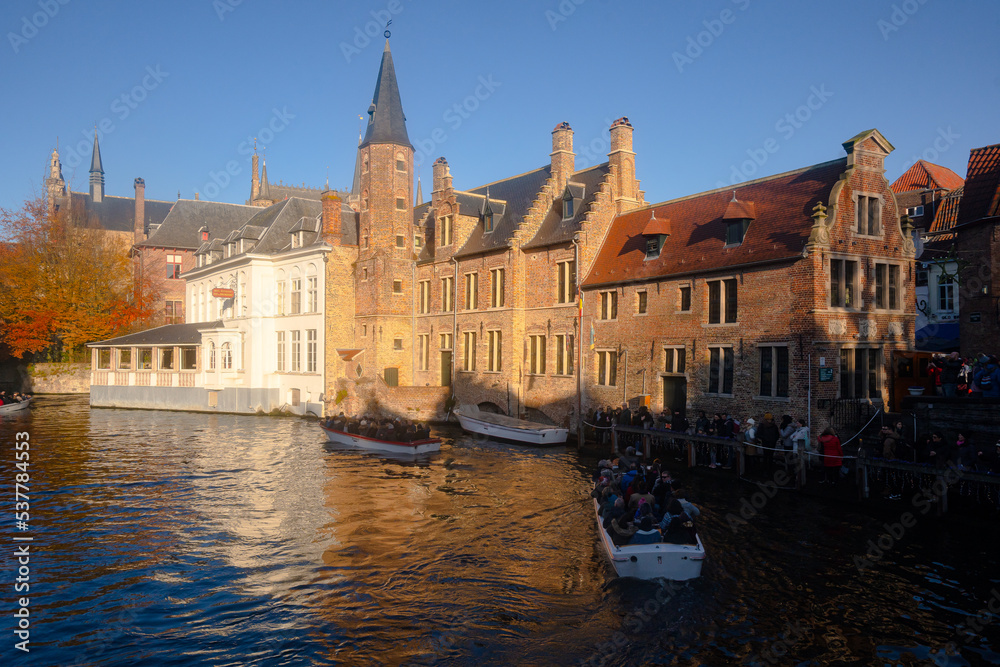 Rozenhoedkaai in Brugge , panoramic view along the canal and medieval buildings in old town during  winter sunny day : Brugge , Belgium : November 30 , 2019