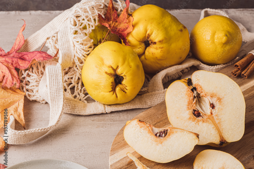 Ripe whole and sliced quinces. Fresh fruit for preparing recipes with cinnamon and lemon. An essential ingredient for a healthy diet