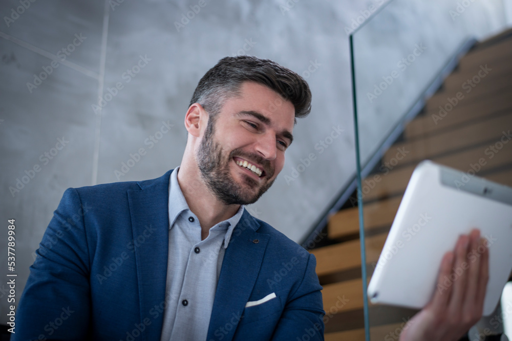 Attractive Businessman using a digital tablet in his office Attractive Businessman using a digital tablet in his office