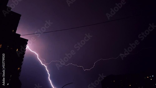Lightning bolts on black sky in the city. High voltage on black background