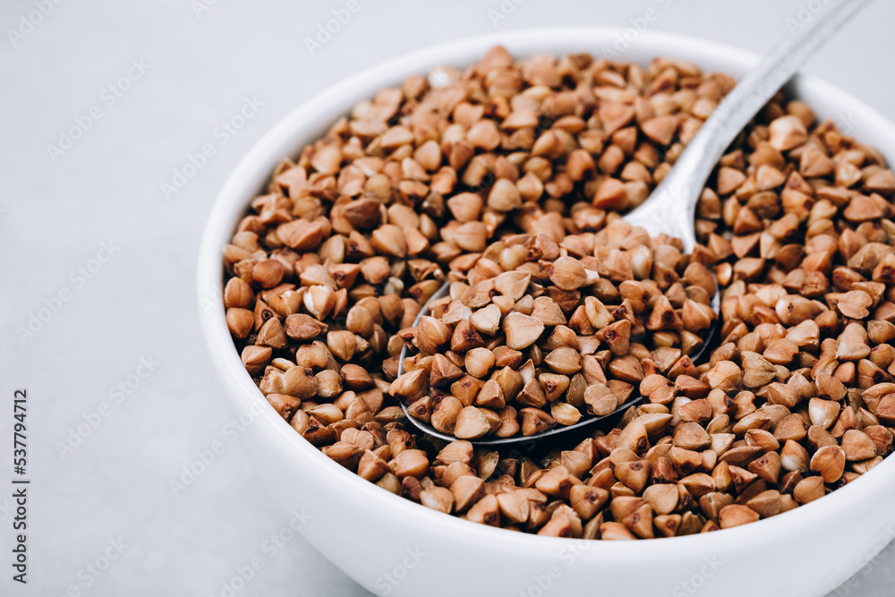 Buckwheat. Organic raw dry Buckwheat grains in bowl on gray stone background. Buckwheat. Organic raw dry Buckwheat grains in bowl on gray stone background.