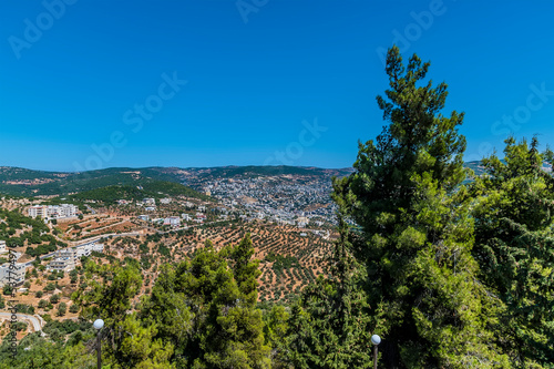 A view past trees across the valley below Ajloun Castle, Jordan in summertime photo