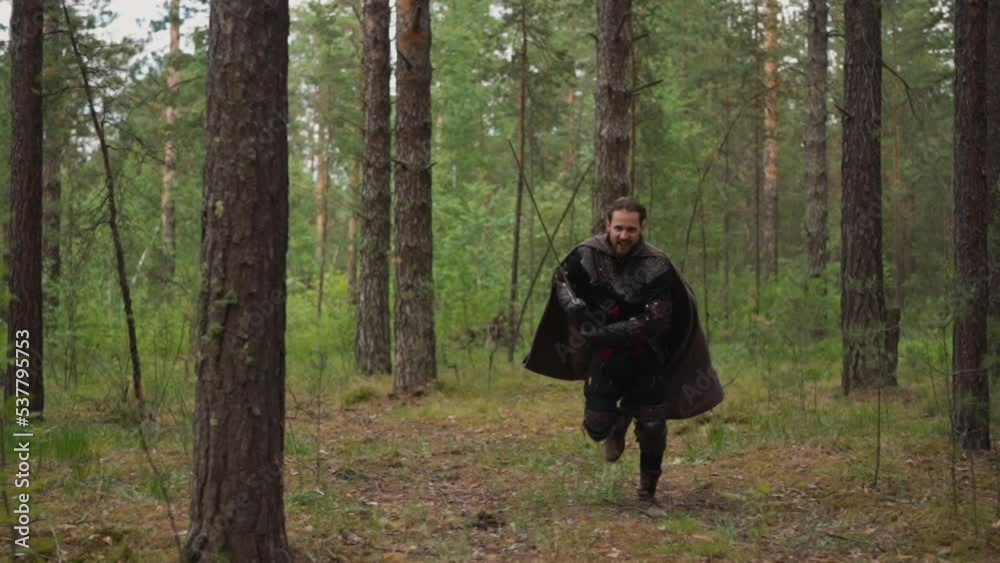 knight in chain mail runs to attack with sword and attacks enemy, close-up, forest landscape knight in chain mail runs to attack with sword and attacks enemy, close-up, forest landscape